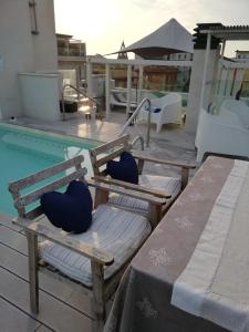 two chairs and a table next to a swimming pool at Hotel Madalù in Rimini