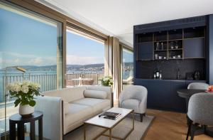 sala de estar con sofá y ventana grande en Alex Lake Zürich - Lifestyle hotel and suites, en Thalwil