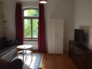 uma sala de estar com um sofá e uma janela em Ferienwohnung Huttenstraße Halle em Halle an der Saale