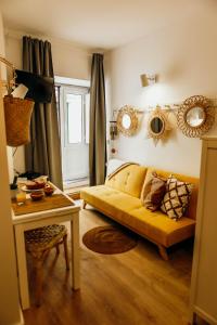 a living room with a yellow couch and a table at Amoreira in Setúbal