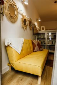 a yellow couch in a living room with mirrors on the wall at Amoreira in Setúbal