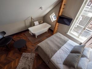 un soggiorno con letto e vasca da bagno di Boutique Hotel Rosenplänter a Pärnu