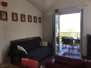 ein Wohnzimmer mit einem Sofa und einem Balkon in der Unterkunft VILLA AS Campo Marzio in Lenno