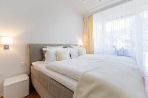 een groot wit bed in een kamer met een raam bij Family Apartment City Center Baden-Baden in Baden-Baden