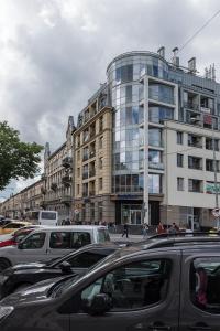 een drukke straat met auto's geparkeerd voor een gebouw bij CITY Aparts Forum in Lviv