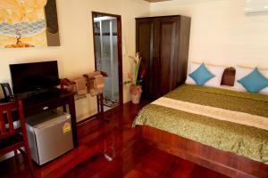 Dormitorio con cama, escritorio y TV en Ao Nang Home Stay - Adults Only, en Ao Nang Beach