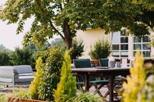 a wooden table and chairs under a tree at Gutshof Sagmühle in Bad Griesbach