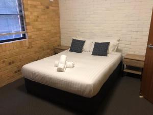 a large bed with white sheets and pillows on it at Hanbury Lodge in Newcastle