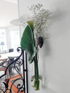 een glazen vaas met bloemen op een muur bij Le Manoir de l'antiquité in Challans