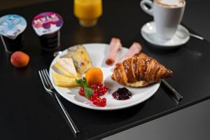 un piatto di prodotti per la colazione su un tavolo con una tazza di caffè di BLOOM Boutique Hotel & Lounge Basel a Basilea