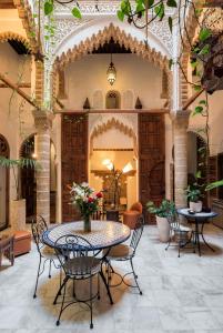 een patio met een tafel en stoelen in een gebouw bij Riad Marhaba in Rabat