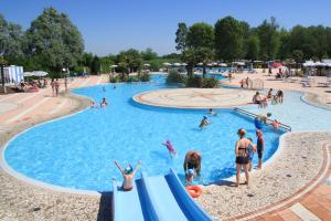 un grupo de personas en una piscina en un parque acuático en Happy Camp Mobile Homes in Camping Laguna Village, en Caorle