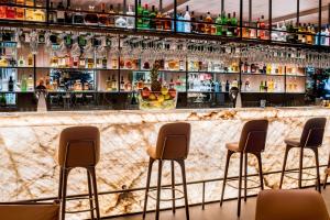 a bar with four chairs in front of a counter at Schweizerhof Zermatt - a Small Luxury Hotel in Zermatt