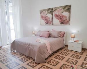 um quarto com uma cama com duas rosas cor-de-rosa na parede em CASACRIZIA em Cagliari