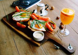 einen Teller mit Essen, ein Sandwich und ein Glas Orangensaft in der Unterkunft Hotel Pomarańczowa Plaża ex Bursztyn in Sopot