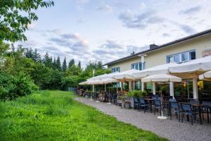 a restaurant with tables and chairs and umbrellas at MEAT UND STAY Hotel in Haar