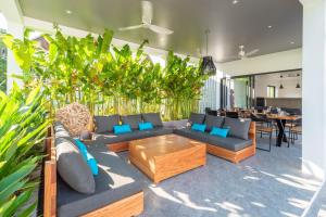 uma sala de estar com sofás, mesas e plantas em Villa Bai Saho em Mae Nam