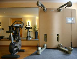 einen Fitnessraum mit einem Laufband und einem Spiegel in der Unterkunft Eden-Hotel in Göttingen