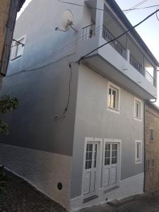 un edificio bianco con porta e balcone di Casa dos Avós e Netos a Fundão