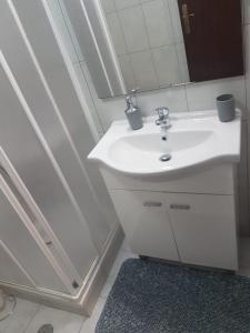 bagno con lavandino bianco e specchio di Casa dos Avós e Netos a Fundão