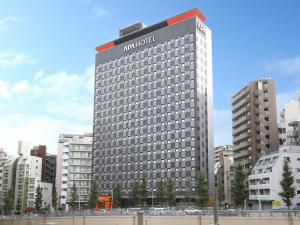 APA Hotel Yamanote Otsuka Eki Tower في طوكيو: مبنى كبير عليه علامة الفندق