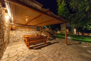 pérgola de madera con banco en el patio en Harmony Deluxe Villas, en Theológos