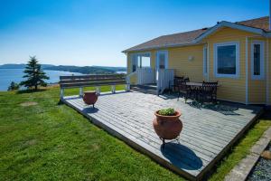 una terrazza con tavolo, panca e casa di The Bayside Bed and Breakfast a Bareneed