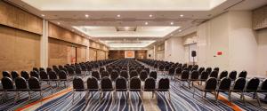 an empty room with black chairs in a hall at HARRIS Hotel and Conventions Kelapa Gading Jakarta in Jakarta