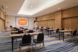 a conference room with tables and chairs and a presentation at HARRIS Hotel and Conventions Kelapa Gading Jakarta in Jakarta