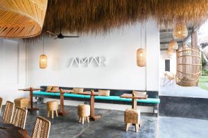 ein Restaurant mit Tischen und Stühlen und ein Schild an der Wand in der Unterkunft Amar Boutique Hotel in Canggu