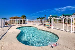 una piccola piscina con recinzione e sedie di Plantation Dunes II a Gulf Shores