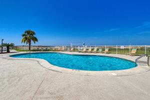 una piscina con acqua blu e una palma di Plantation Dunes II a Gulf Shores