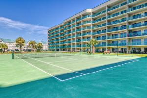 un campo da tennis di fronte a un grande edificio di Plantation Dunes II a Gulf Shores