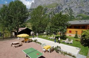 eine Gruppe von Personen, die um eine Terrasse mit einem Tisch und Stühlen stehen in der Unterkunft Alfa Appartements Superior in Leukerbad