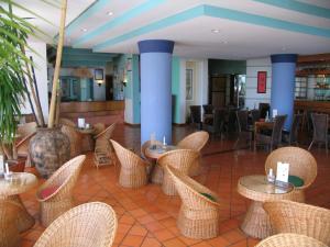 een restaurant met rieten tafels en stoelen bij Hotel Jardim Atlantico in Calheta