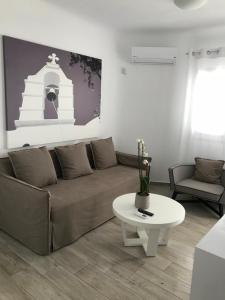 a living room with a couch and a table at Livin Mykonos Hotel - Adults Only in Mýkonos City