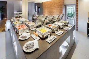 a buffet line with many trays of food at GHV Hotel in Vicenza