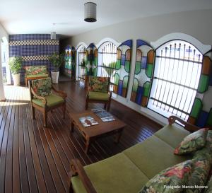 a living room with furniture and stained glass windows at Pousada Portal do Mar in Cabo Frio