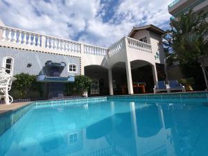 a swimming pool in front of a house at Pousada Portal do Mar in Cabo Frio