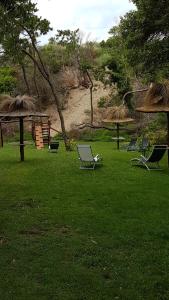 een groep stoelen in het gras bij Cabañas Victoria in Mar de las Pampas