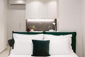 a bedroom with a green and white bed with white pillows at Thess Residences in Thessaloniki