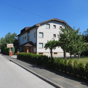 een groot wit gebouw aan de straatkant bij Rooms and Apartments Panker in Moravske-Toplice