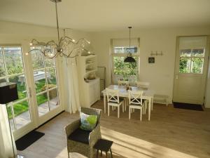 a kitchen and dining room with a table and chairs at Luxe vakantiewoning Zeeduinsepoort met Sauna in Oostkapelle