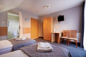 a hotel room with two beds and a bathroom at Hotel Wena in Kielce