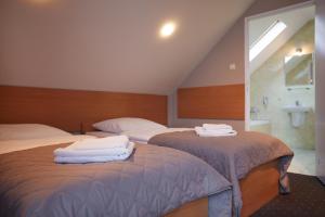 two beds with towels on them in a bedroom at Hotel Wena in Kielce