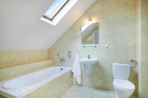 a bathroom with a tub and a toilet and a sink at Hotel Wena in Kielce