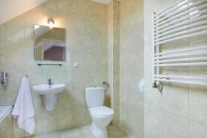 a bathroom with a toilet and a sink and a mirror at Hotel Wena in Kielce