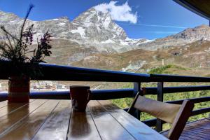 a table on a balcony with a view of a mountain at Marcolski home in Breuil-Cervinia