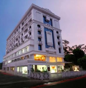 un gran edificio blanco con luces encendidas en Hotel Airlink Castle, en Nedumbassery