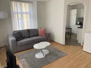 een woonkamer met een bank en een tafel bij Haus zur Eiche Private 3,5 Zimmerwohnung bis zu 8 Gäste in Chur